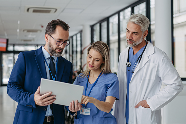 Gespr&auml;chsituation von drei Personen auf einem Krankenhausflur