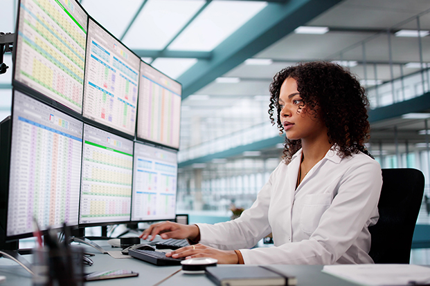 Laborantin an einem Computer mit sechs Monitoren