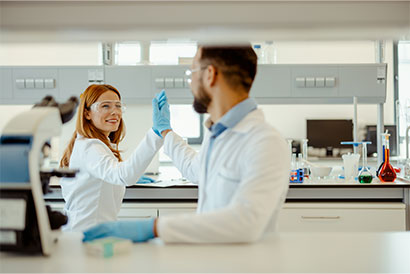 Zwei Wissenschaftler im Labor feiern ein erfolgreiches Experiment mit High-Five